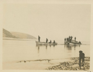 Image of Three open boats with men aboard. Two boats are loaded with supplies